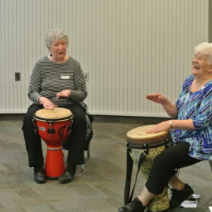 Two drum circle participants smiling and laughing